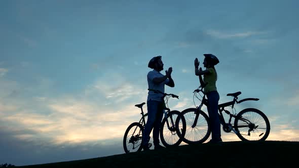 Couple of Cyclists Clapping Hands Together