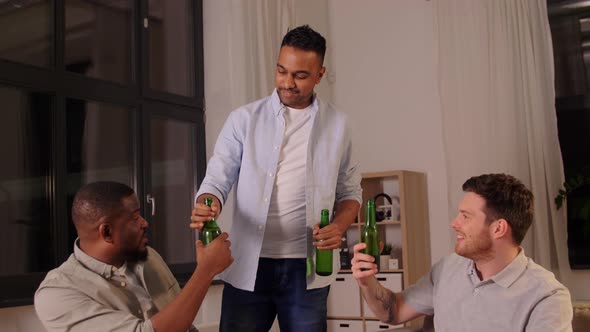 Happy Male Friends Drinking Beer at Home at Night