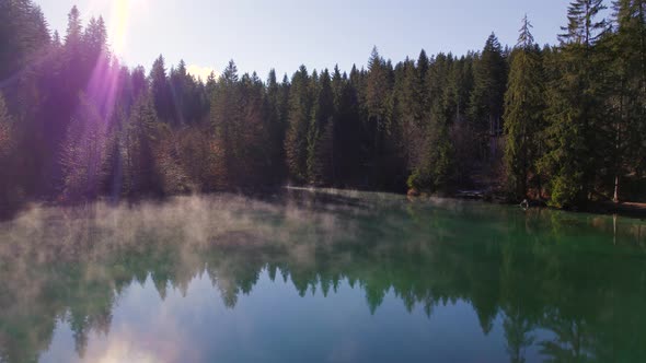 Crestasee Lake in Switzerland Reflecting the Forest in the Misty Emerald Waters