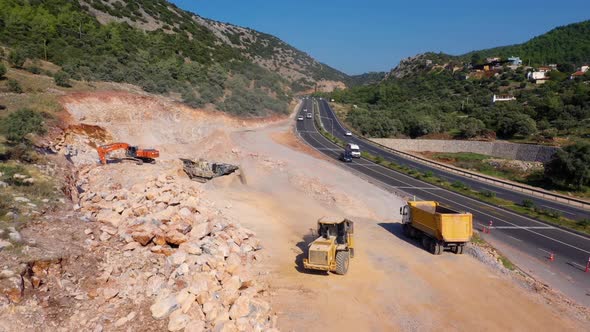 Aerial Drone View of Heavy Machinery Working at Mountain Quarry Near the Road