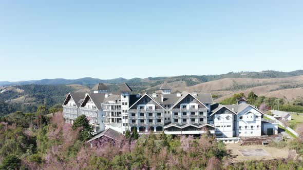 Front aerial view of an abandoned luxury hotel Mont Blanc in campos de jordao brasil, dolly in shot