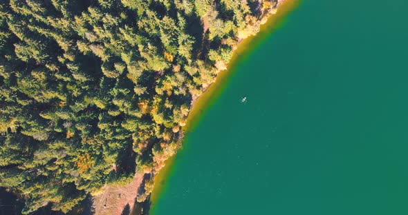 Top Down View Of Turquoise Water With Kayak At Lake Saint Ann In Romania - aerial drone shot