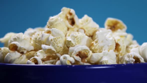 Cooked Popcorn in a Plate on a Blue Background