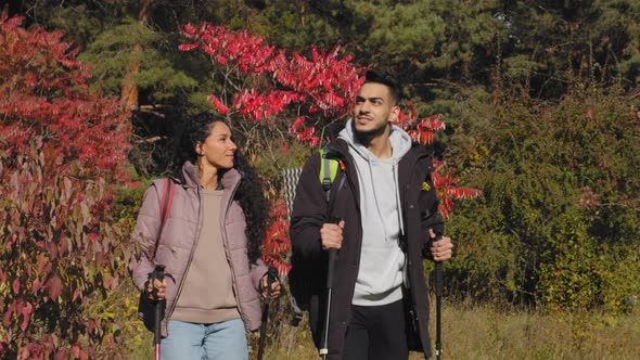 Young Happy Married Couple Hikers Walk in Beautiful Park Travel with Backpack Guy and Girl in Love
