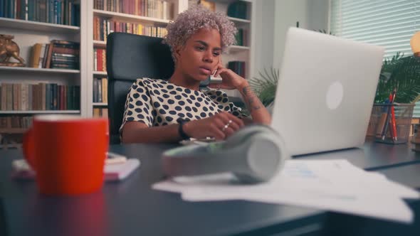 Serious Focused Young Woman Working on Laptop While Sitting in Home Office