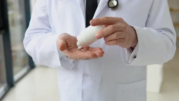 Senior Doctor Pouring Pills From Bottle