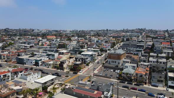 Aerial view overlooking the cityscape of Hermosa, in sunny Los Angeles, USA - rising, drone shot