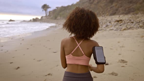 Slow motion shot of an Somali woman jogging on the beach