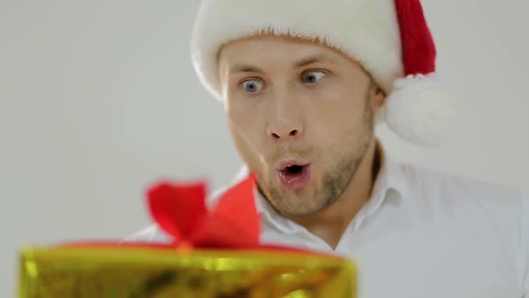 Portrait of a beautiful man in Santa's hat with a fun face image, white background