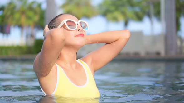 Young asian woman enjoy around outdoor swimming pool for leisure