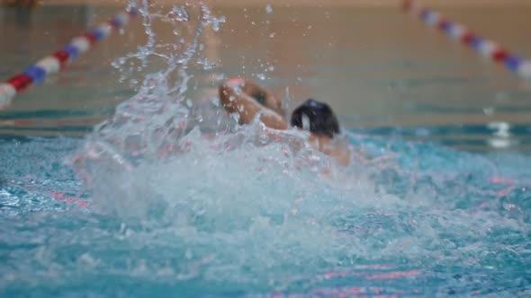 Young Man Swimmer Training in the Water of a Training Pool Indoors