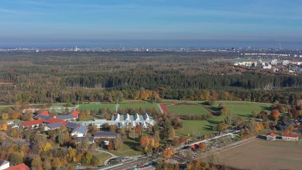 Autumn landscape of a village with playgrounds for soccer and the skyline of the bavarian city Munic