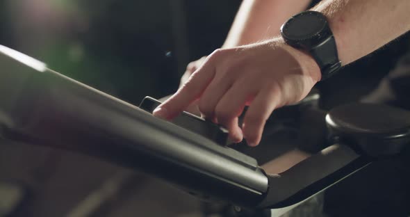 Male Hand with Wristwatch Typing on Simulator's Smart Screen in a Gym