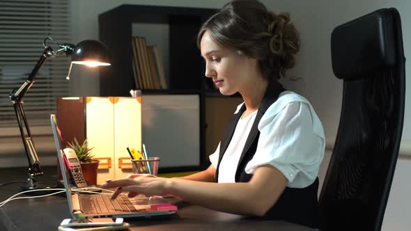 Businesswoman Sitting At Her Workplace In Office And Working At Laptop