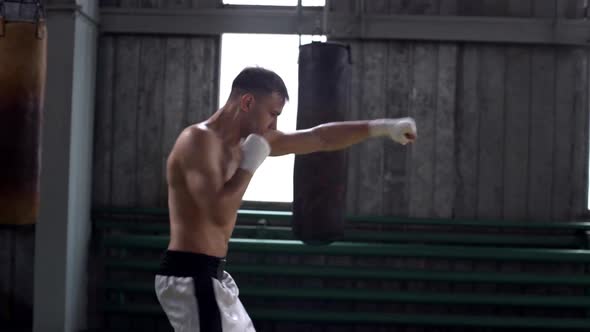 Portrait of Strong Active Man in Sport Shorts Boxing and Punching Invisible Opponent While Training