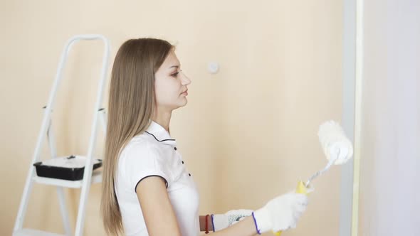 Cheerful Young Couple in White Shirts Decorate Their New Apartment