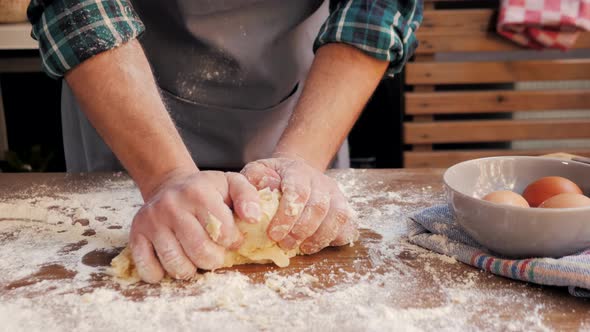 Male Hands Clapping and Sprinkling White Flour Over Dough on Kitchen