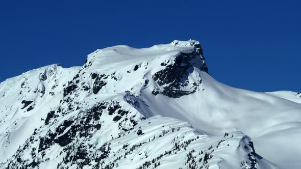 Snowy Mountain Summit And Blue Sky In Winter - aerial shot