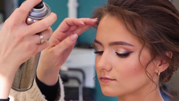 Closeup of a Girl's Face Her Hair is Styled Splashing Varnish