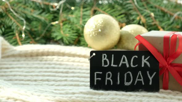 Gift Box and Promotional Sign of Black Friday on the Christmas Background