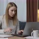 Portrait of a young caucasian woman sitting at the desk with laptop, typing an email, messaging - VideoHive Item for Sale