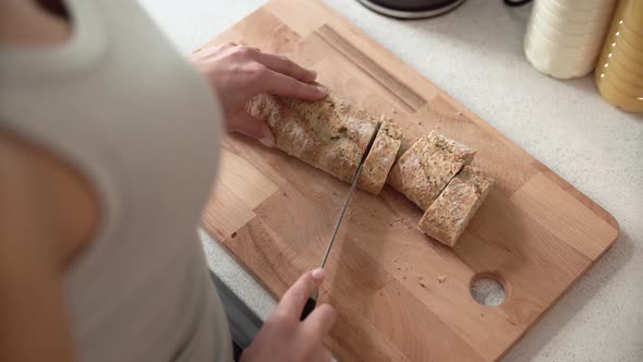 Cutting Bread On Wooden Board By Woman Hands Closeup