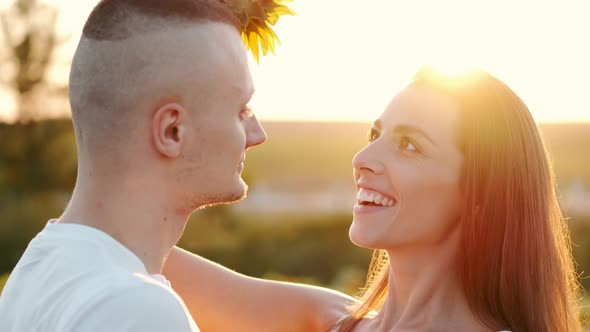 Happy Young Attractive Couple in Sunflower Field Together at Sunset in Slow Motion