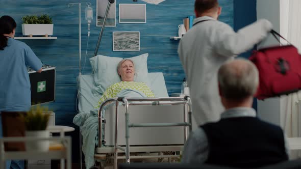 Elder Woman with Sickness Receiving Visit From Doctor and Nurse