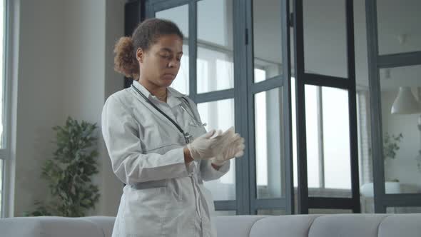 African Female Doctor Putting on Medical Glove