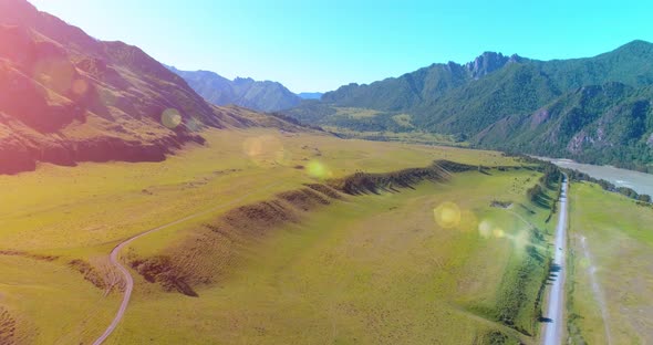 Aerial Rural Mountain Road and Meadow at Sunny Summer Morning. Asphalt Highway and River.