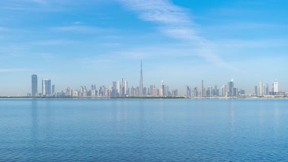 Time lapse of Dubai Downtown skyline with waves on sea beach, United Arab Emirates or UAE