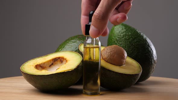 Avocado oil with avocado fruit on wooden table. Avocado is a highly nutritious fruit.