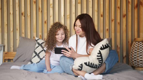 Brunette Mother and Kid Daughter Talk with Dad on Video Call