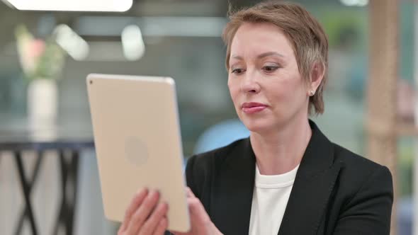 Attractive Old Businesswoman Using Tablet 