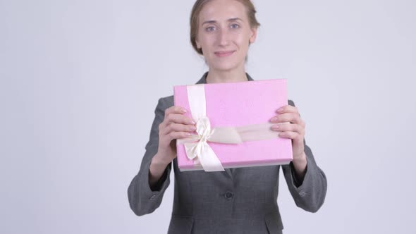 Happy Young Blonde Businesswoman Giving Gift Box