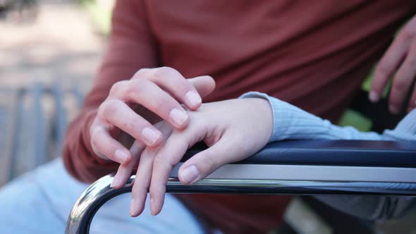 symbol of empathy - hand of young man takes that of girlfriend with paraplegia