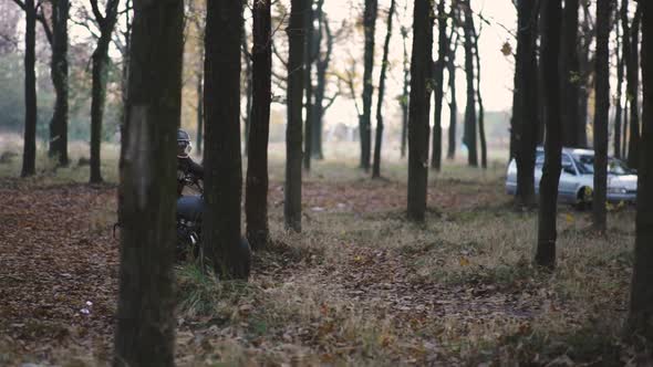 Man Riding Old Custom Caferacer Motorcycle on Forest Country Road at Sunset