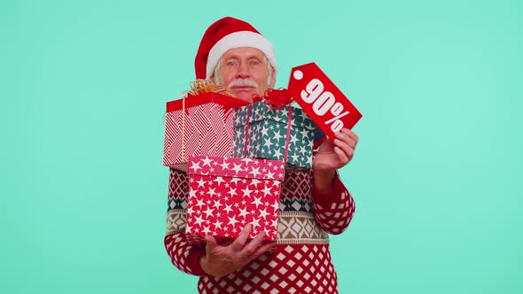 Senior Man in Christmas Sweater Showing Gift Box and 90 Percent Discount Inscriptions Banner Text