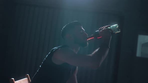 Man drinking wine alone in a dark room