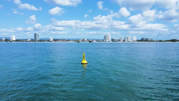 Revealing a yellow marine speed limit marker buoy sits anchored in calm waters of a major waterway z