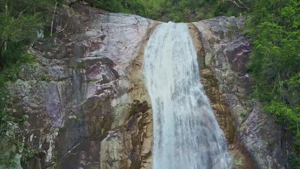 Flycam Moves To Stormy Waterfall Top on Cliff Against Jungle