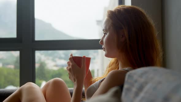 Woman having coffee in living room 