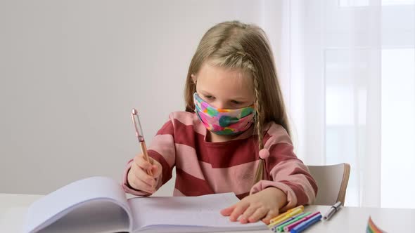 Little girl child wear face protective mask studying at school in classroom 
