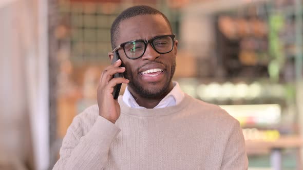 Portrait of Cheerful African Man Talking on Smartphone