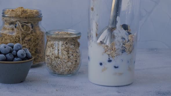 Woman Preparing Healthy Blueberry Smoothie with Blender