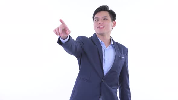 Happy Young Asian Businessman Pointing Finger and Directing