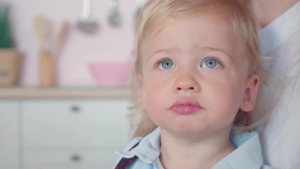 Close-up Face of Charming Little Blond Boy with Blue Eyes Chewing Cookie, Portrait of Cute Caucasian