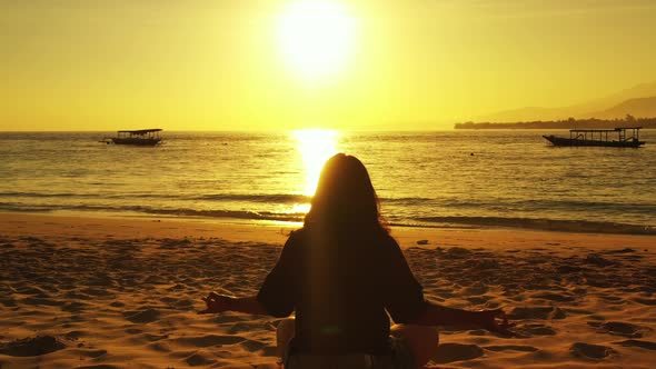 Modern smiling girl travelling spending quality time at the beach on summer white sand and blue 4K b