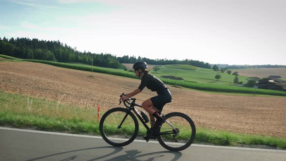 Woman cycling on country road during triathlon training