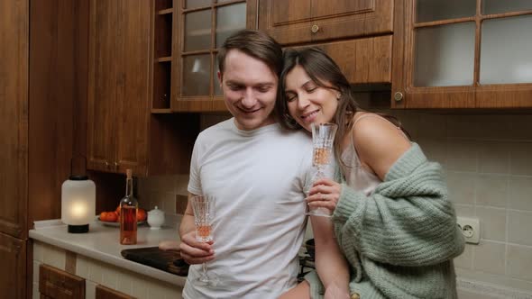 Romantic Couple That Enjoys a Glass of Wine and Relaxing in Kitchen